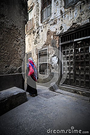 Veiled woman walking through a narrow street Editorial Stock Photo