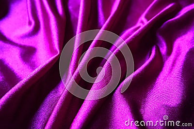 Velour fabric, similar to silk. Textiles in a folds and beautiful waves. Purple, pink, magenta shades on the drapery Stock Photo