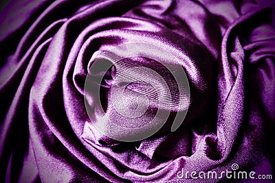 Velour fabric, similar to silk. Textiles in a folds, beautiful waves, twisted into a circle. Purple, pink, magenta Stock Photo