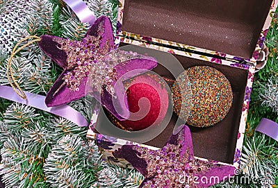 Velvet stars and Christmas balls in a casket on the background of the Christmas tree Stock Photo