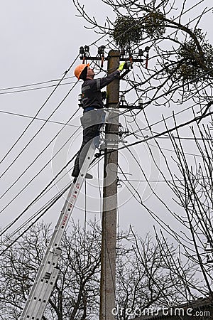 Velyka Vilshanytsia, Ukraine - March 9, 2023: A worker repairs a power line following a Russian missile strike in Lviv region Editorial Stock Photo