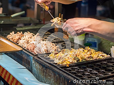 Vendor making giant Takoyaki with cheese at Shilin Night Market. Stock Photo