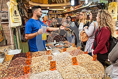 Vendor meeting group of people for degustation at the Machane Yehuda Market in Jerusalem, Israel Editorial Stock Photo