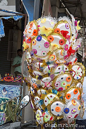 Vendor selling umbrella for devotees to bless Hindu god Ganesh at local market on the first day of Ganesh Editorial Stock Photo