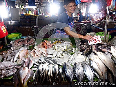 A vendor sells different kind of fishes at a wet market. Editorial Stock Photo