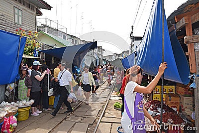 Vendors are keeping their stalls away from the coming train at Maeklong Railway Market. Editorial Stock Photo