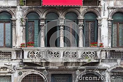 Red flowers on a vintage balcony in Venice. Stock Photo