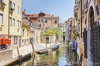 Venice as it is: canal, gondolas, bright buildings and tourists at noon time. Editorial Stock Photo