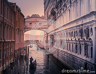 Gondolier rows down a canal towards the historic Bridge of Sighs Editorial Stock Photo