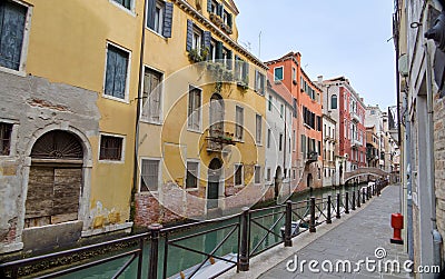 Venice Canal View with Stone Walkway and Distant Bridge Editorial Stock Photo