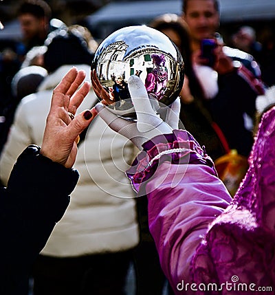 Venice Carnival Participant and Reveller Looking into Silver Ball Editorial Stock Photo