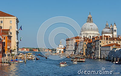Venice, Italy - April 20, 2019: Traffic rush on Grand Canal with boats, gondolas and Venetian vaporetto. Basilica Santa Maria Editorial Stock Photo