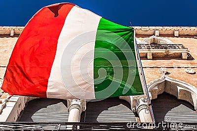 VENICE, ITALY - AUGUST 20, 2016: Italian flag and facades of old medieval buildings close-up on August 20, 2016 in Venice, Italy Editorial Stock Photo