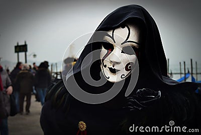 VENICE, ITALY - Feb 09, 2016: A Venetian masquerade in costume with a sad mask at the carnival of Venice Editorial Stock Photo