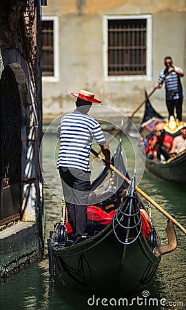 VENICE, ITALY - JULY 12 : Gondolier plying his trade in Venice Italy Editorial Stock Photo