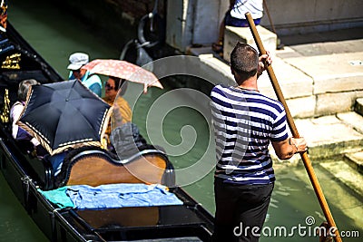 VENICE, ITALY - JULY 12 : Gondolier plying his trade in Venice Italy Editorial Stock Photo