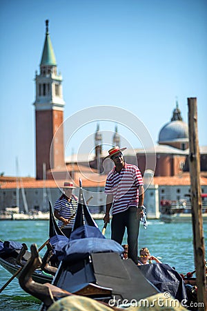 VENICE, ITALY - JULY 12 : Gondolier plying his tradein Venice Italy. Editorial Stock Photo