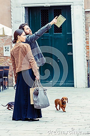 Beautiful thirties couple very well dressed with their dogs in a street Editorial Stock Photo