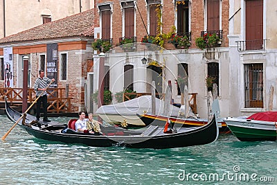 VENICE, ITALY - OCTOBER 26 : Gondolier ferrying passengers along Editorial Stock Photo