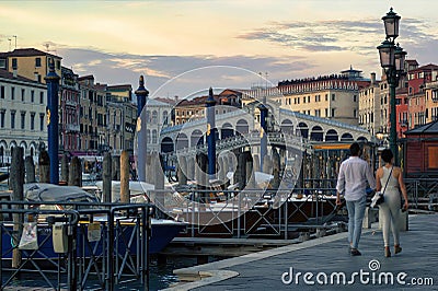 Venice, Italy: A couple walking holding hands against rialto bridge, a famous place known as one of the Editorial Stock Photo