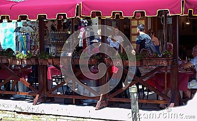 Venice, Italy - September 03, 2018: People and tourist eating outside in the restaurant next to canal Editorial Stock Photo