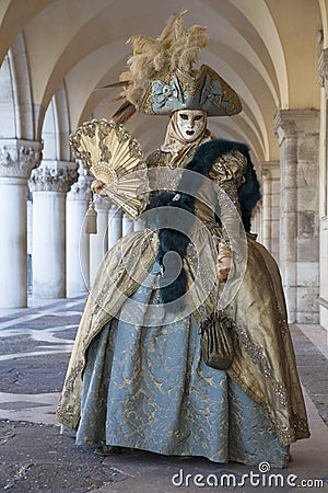 Venice masks and wearing turquoise and gold Venice costumes worn at the Venice Carnival Italy Editorial Stock Photo