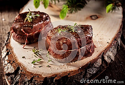 Venison Steak Filets Served on Rustic Wood Plank Stock Photo
