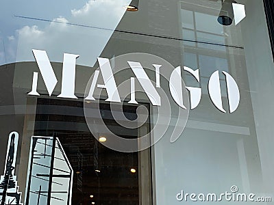 View on storefront window with logo and lettering of international fashion group Mango Editorial Stock Photo