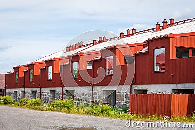 Perspective outdoor summer view of many red wooden buildings in a row. Stock Photo