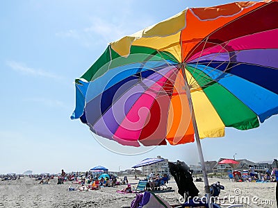 Ventnor,New Jersey - May,2022: A large colorful beach umbrella on a crowded beach Editorial Stock Photo