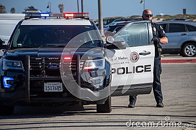 An officer from the City of Ventura Police Department exits his car at a search Editorial Stock Photo