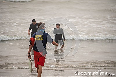 A lifeguard at Ventura Harbor makes contact with swimmers to advise them Editorial Stock Photo