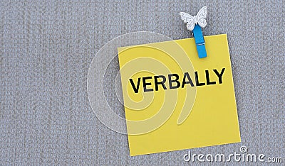 VERBALLY - words on yellow paper with clothespin on gray background Stock Photo