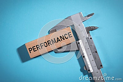 Vernier caliper with a Performance word on wooden block Stock Photo