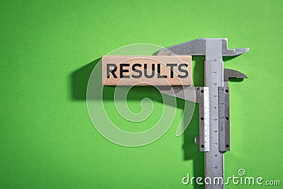 Vernier caliper with a Results word on wooden block Stock Photo