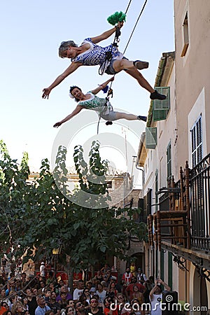 Acrobats during show on buildind facade vertical Editorial Stock Photo