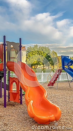 Vertical Bright orange and blue slides at a colorful fun playground for children Stock Photo