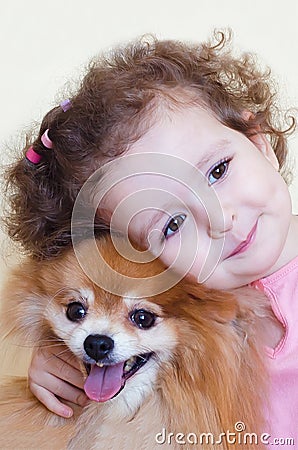 Child hugs his dog with love. childhood friends. happy girl and pomeranian Stock Photo