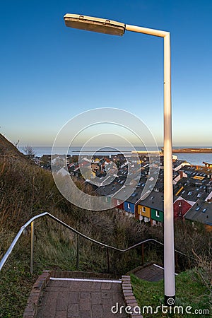 Vertical cityscape of Helgoland, Germany, taken from the cliff above the city. Staircase going down in the front, on a Editorial Stock Photo