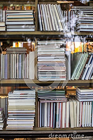 Vertical close-up of a bookshelf, displaying various types of books Editorial Stock Photo