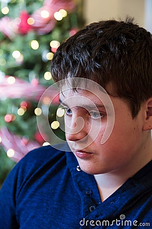 Vertical closeup of cute glum round-faced teenager boy Stock Photo