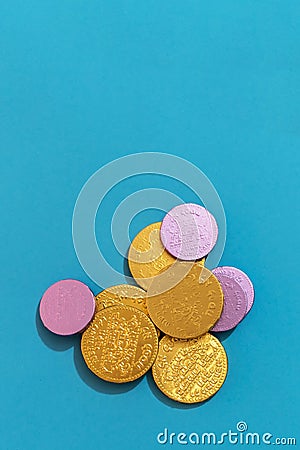 Vertical closeup of Hanukkah gelt or chocolate coins on a light blue background Stock Photo