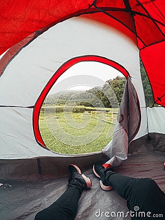 Vertical closeup shot of female legs with boots in the tent - concept of hiking Stock Photo