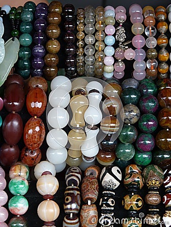 Vertical closeup shot of rows of colorful beaded jewelry in a market Stock Photo