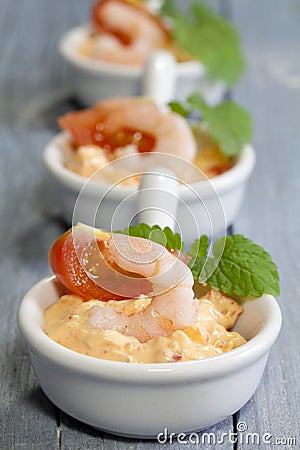 Vertical closeup shot of salads with shrimp and tomato in small white bowls Stock Photo