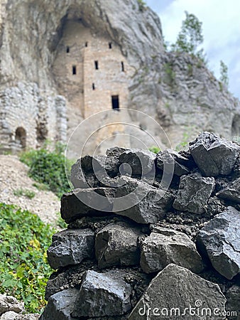 Vertical closeup shot of a stack of gray rocks near a stone wall Stock Photo