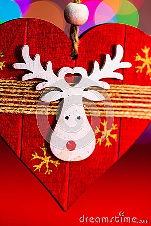 Vertical closeup shot of a wooden handmade decoration with a reindeer against the bokeh lights Stock Photo