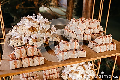 Vertical closeup of small packs on shelves decorated with flowers indoors Stock Photo