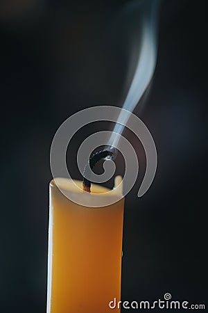 Vertical closeup of a smoking candle on a blurry background Stock Photo