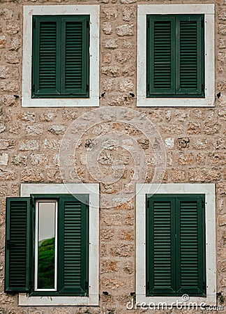 Vertical closeup of a two-story house with green shuttered windows Stock Photo